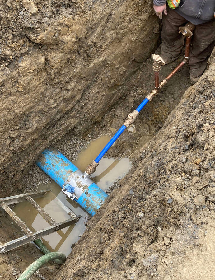 Water tap on new construction with water meter set and curb stop.